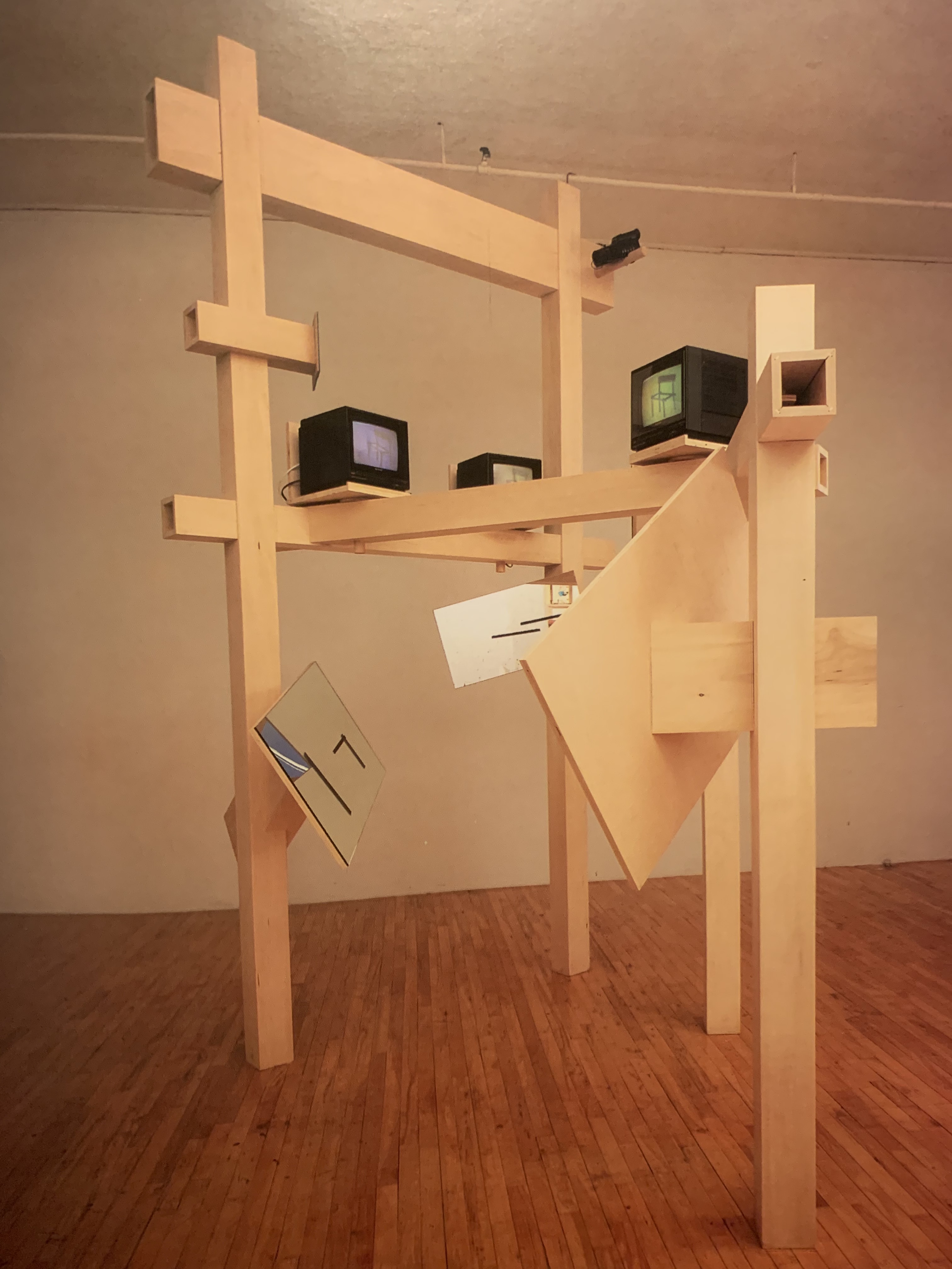 The Big Video Chair (1987) by Buky Schwartz — Closed-circuit video installation — wooden timbers, monitors, camera, painted panels and mirror